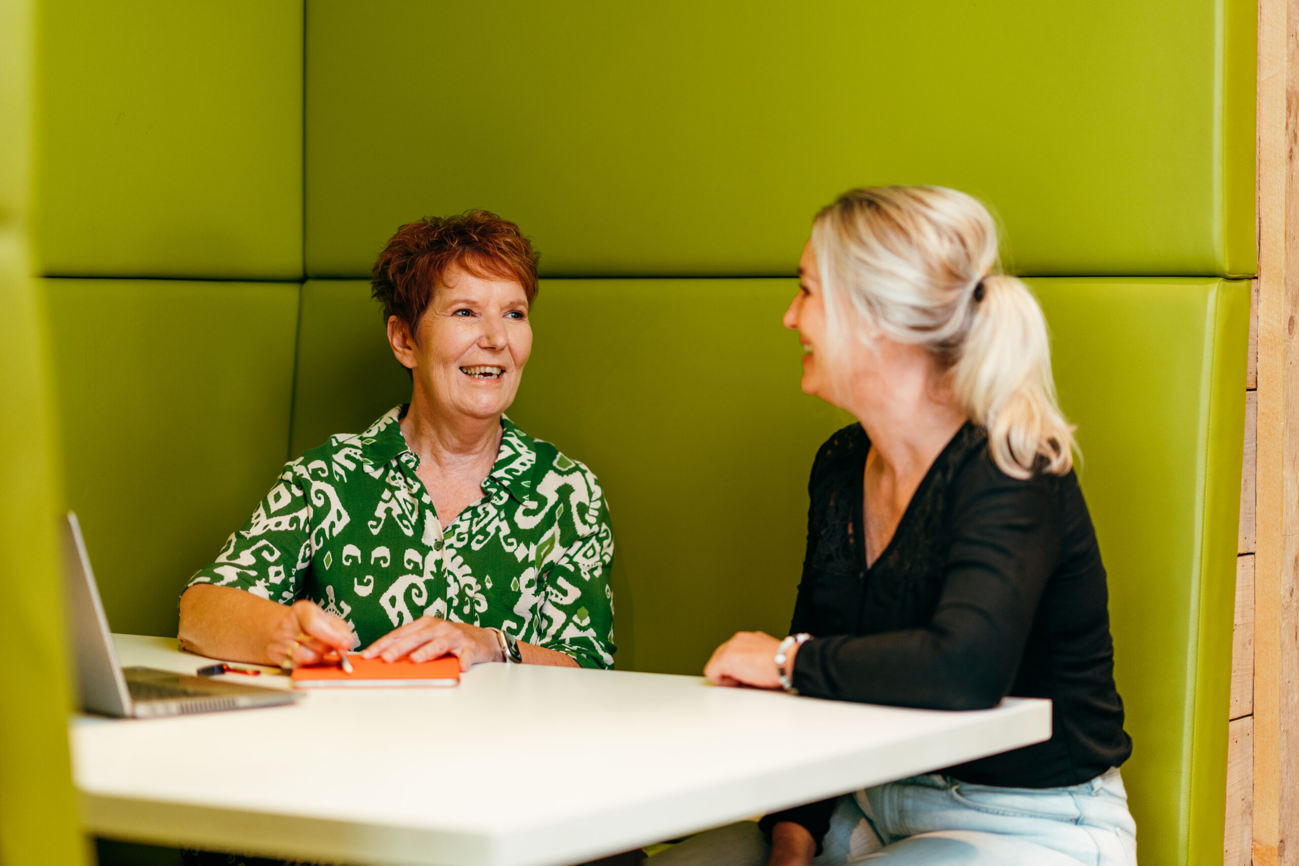 Twee vrouwen overleggen aan een tafel